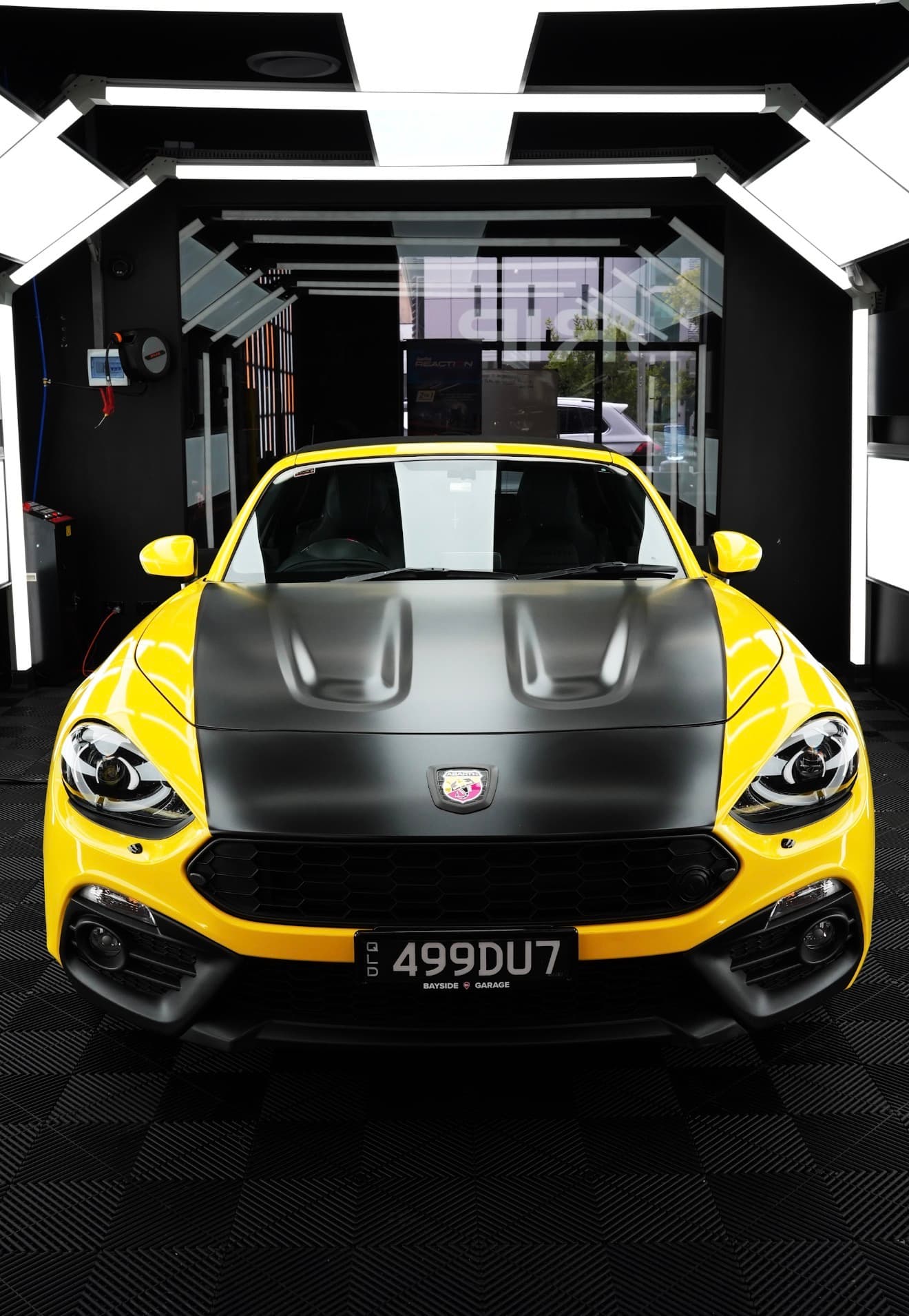 Vinyl wrap from the DRIP portfolio — Abarth 124 Spider yellow with matte black hood wrap