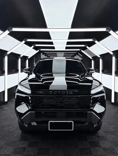 Gloss black truck in the DRIP light-tunnel studio after paint protection work